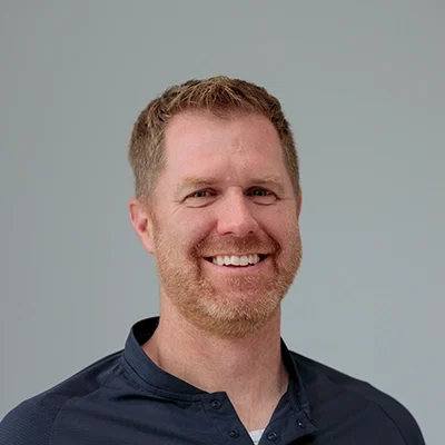 Chiropractor Ryan Griffeth Smiling In Blue Polo